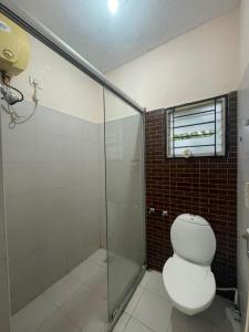 a bathroom with a toilet and a glass shower at Varsha's Nest at Uthandi in Chennai +11 photos