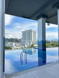 a swimming pool with a view of a building at Deluxe 2BR Seaview and Mountain View with balcony in Kota Kinabalu