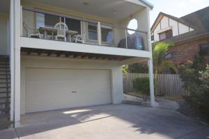 a house with a garage door and a balcony at 3-36 Manooka Drive - Rainbow Beach - Sea Views and breezes in Rainbow Beach