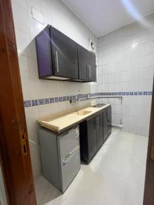 a kitchen with black cabinets and a counter top at شقة راقية للايجار اليومي in Taif