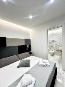 a white bedroom with a large bed and a bathroom at Oltremare Luxury Suites in Bari