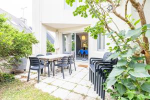 an outdoor patio with a table and chairs at Family vacation home 100 m from beach - Ty For Tous in Île-Tudy