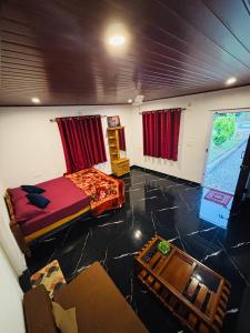 a room with a bed and a table in it at Coorg Sunrise Cottage Homestay in Kushālnagar