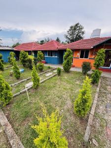a garden in front of a house with trees and bushes at Coorg Sunrise Cottage Homestay in Kushālnagar