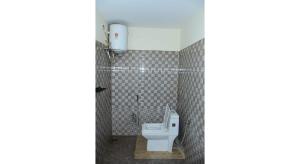 a bathroom with a white toilet in a stall at HS Cottage Ooty in Ooty