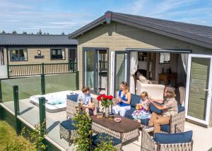 a group of children sitting on the deck of a house at Heathergate Boutique Holiday Park in Hexham