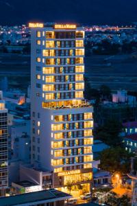 un edificio alto con luci sopra di esso di notte di Stella Maris Nha Trang Hotel a Nha Trang