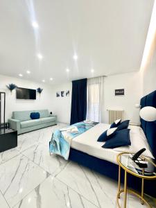 バーリにあるOltremare Luxury Suitesの大きなベッドとソファのある寝室