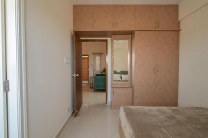 バンガロールにあるHomeSlice Manor, Premium Apartment in Whitefieldのベッドルーム1室(ベッド1台付)、廊下へのドアが備わります。