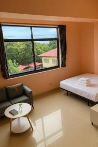 a room with a bed and a couch and a window at T1 Stay Manila-Near NAIA Manila Airport and PITX in Manila