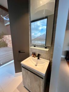 a bathroom with a sink and a window at The Leopard Rock Suite with uninterrupted beach views in Hout Bay