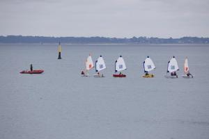 a group of sailboats on the water with a lighthouse at Pioka Loft Art & Surf in Plouharnel