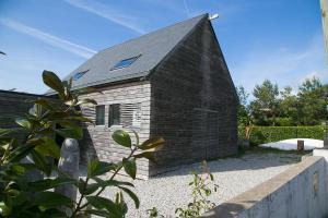 a small brick house with a black roof at Pioka Loft Art & Surf in Plouharnel