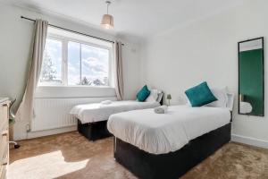 a bedroom with two beds and a window at Modern 3Bed Escape - Work&Relax - Free Parking in Chigwell