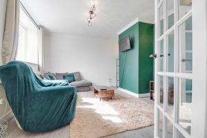 a living room with a green chair and a couch at Modern 3Bed Escape - Work&Relax - Free Parking in Chigwell