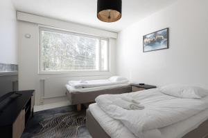 Un pat sau paturi într-o cameră la Kotimaailma Aparthotel Ankkuri - 4 Bedroom