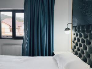 a bedroom with a bed and a window at Suru Hotel & Restaurant in Buşteni