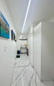 a hallway with white walls and a marble floor at Oltremare Luxury Suites in Bari +52 photos