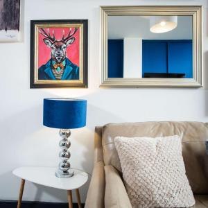 a living room with a couch and a blue lamp at The Luxury Canvas by The Hive WA1 in Warrington