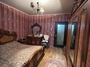 a bedroom with a bed and a large mirror at ismayil Iki in Baku