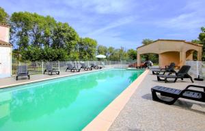 una piscina con tumbonas y sillas alrededor en Cozy Home In Lablachère With Swimming Pool, en Lablachère