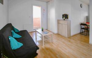 Una sala de estar con un sofá negro y una mesa. en Cozy Home In Lablachère With Swimming Pool, en Lablachère
