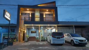 a white car parked in a parking lot in front of a house at Aura Syaria Guest House in Bukittinggi +30 photos