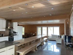 a large kitchen with a long bench in a room at Hideout Villa Hilikkula in Rokua
