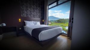 a bedroom with a bed and a large window at Aura Syaria Guest House in Bukittinggi