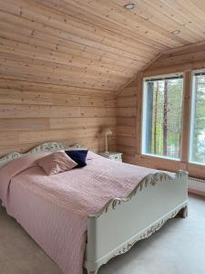 a bedroom with a bed in a wooden wall at Hideout Villa Hilikkula in Rokua