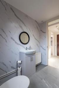 a white bathroom with a sink and a mirror at Spacious 2br Near Queens Uni & City Centre in Belfast