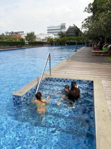 a group of people in a swimming pool at Family Suite at Landmark Residence in Bandung