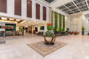 ガーズィヤーバードにあるCountry Inn & Suites By Radisson, Sahibabadのテーブルの上に花瓶が置かれたロビー
