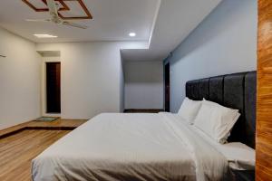 スーラトにあるHotel O Honey Innの白いシーツが敷かれた大きなベッドのある寝室