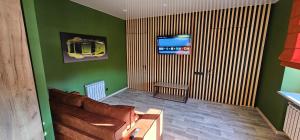 a living room with a couch and a tv at Wood Appartment on Svobody in Kamianske