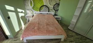 a bed in a green room with a bedspread at Wood Appartment on Svobody in Kamianske