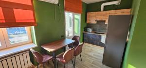 a kitchen with green walls and a table and chairs at Wood Appartment on Svobody in Kamianske
