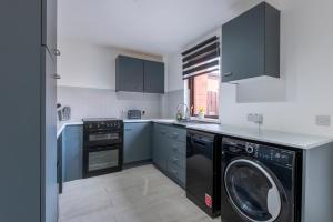 a kitchen with a washer and a dishwasher at Spacious 2br Near Queens Uni & City Centre in Belfast +27 photos