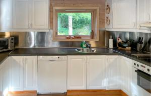 une cuisine avec des armoires blanches, un évier et une fenêtre dans l'établissement 3 Bedroom Cozy Home In Farsund, à Helle