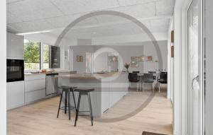 a white kitchen with a counter and stools in it at Lovely Home In Fårvang With Sauna in Roe