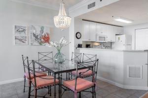 a dining room with a table and chairs and a kitchen at Beach Club Bristol 202 Condo in Gulf Highlands +39 photos