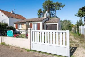 ein weißer Zaun vor einem Haus in der Unterkunft 800 m de la plage, jardin, maison pour 5 in Saint-Michel-Chef-Chef