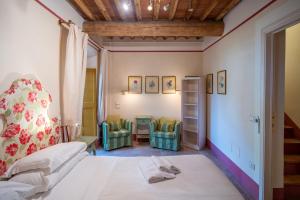 ein Schlafzimmer mit einem Bett und zwei Stühlen in der Unterkunft Bertolli Villas in Matraia