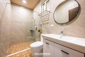 Un baño con inodoro, lavabo y espejo. en LaiKe B&B, en Xiaoliuqiu