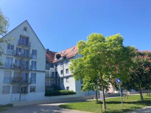 a white building with a tree in front of it at Ferienwohnung Seeblick in Lindau