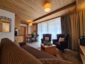 a living room with a couch and chairs and a table at Apartment ALFA with jacuzzi in Demanovska Dolina