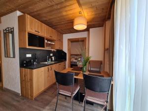 a kitchen with a table and chairs in a room at Apartment ALFA with jacuzzi in Demanovska Dolina