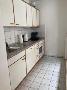 a kitchen with white cabinets and a sink at Ferienwohnung Seeblick in Lindau