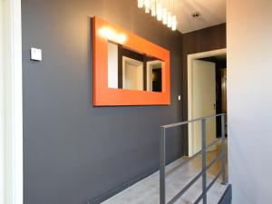 a hallway with an orange mirror on a wall at Modern Cottage in Vaux-sur-Sûre with Sauna in Morhet +45 photos