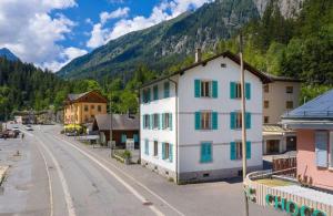 a town with a building with green and white windows at La Maison des Amis - A in Le Chatelard
